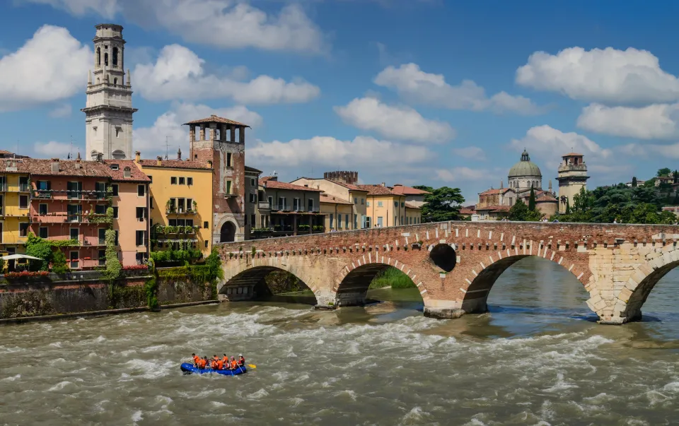 Ponte Pietra crossing the Adige River beside colourful buildings in Verona