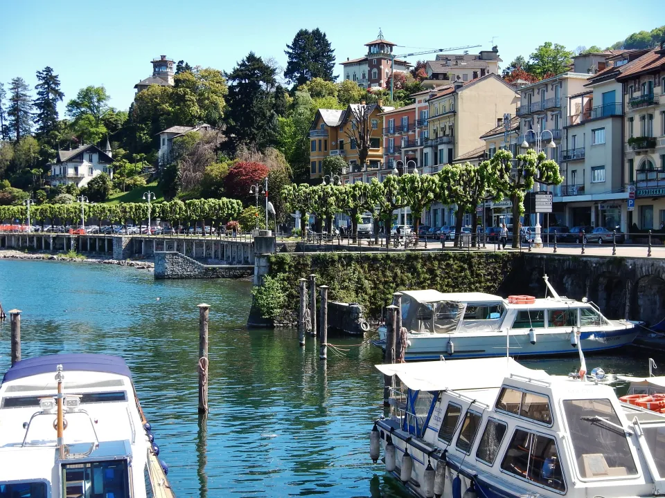Moored boats beside Stresa's tree-lined waterfront and colourful buildings