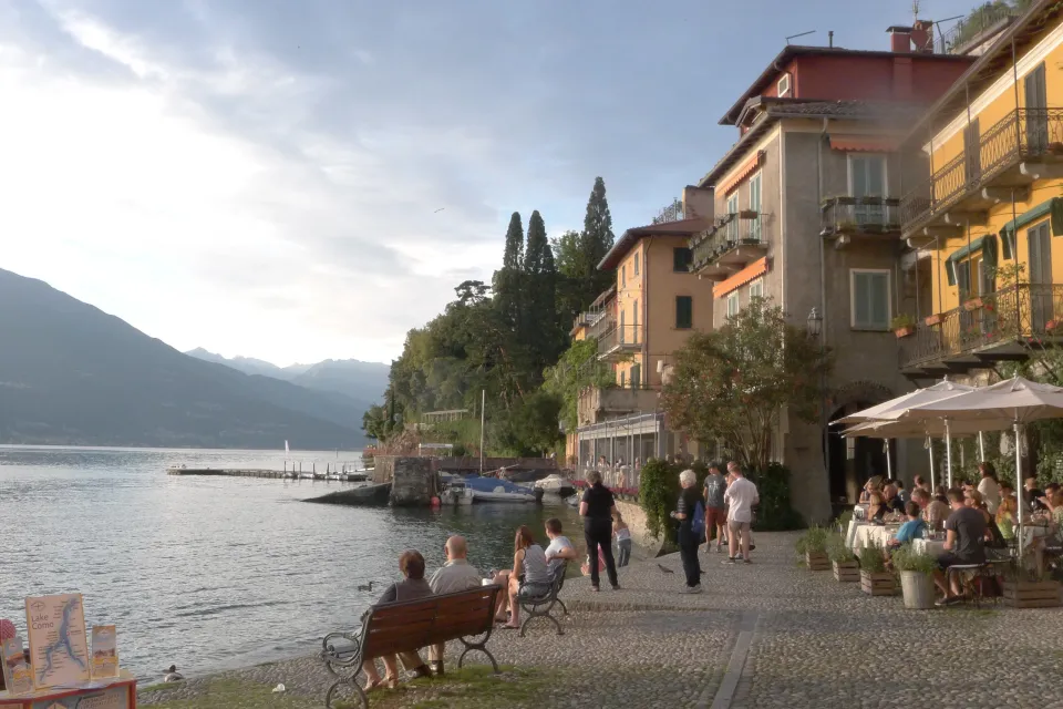 People walking beside the lake and colourful waterfront buildings in Varenna