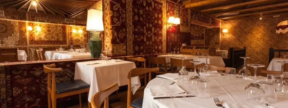 Les Quinze Nitsの店内。柄の壁と柱に囲まれた、白いクロスのテーブル席。