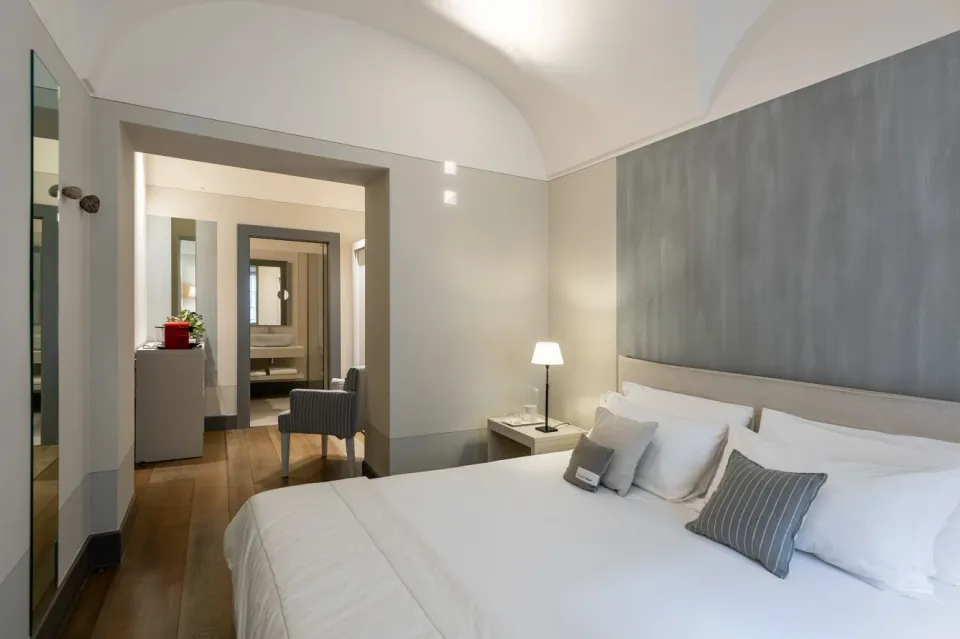 ゴンビットホテルのClassic Room、白い丸天井、グレーの壁と木の床、ダブルベッド