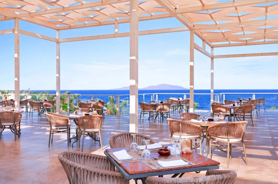 Royal GrandのSoprano Restaurantの海向きテラス。白い幾何学模様の日除けと籐の椅子