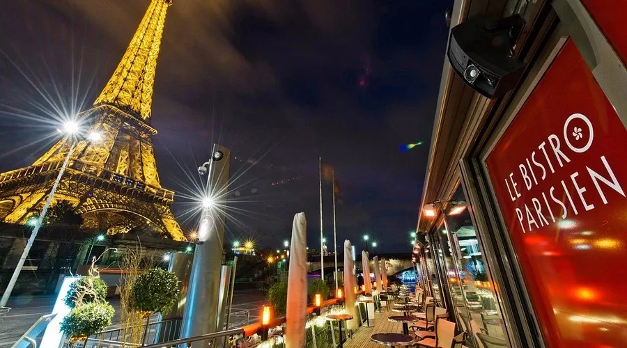 Le Bistro Parisienのテラスと夜のエッフェル塔