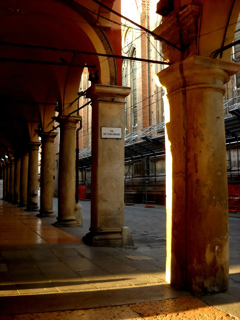 Sunlit columns in the Portico del Pavaglione at the Via de’ Foscherari corner in Bologna