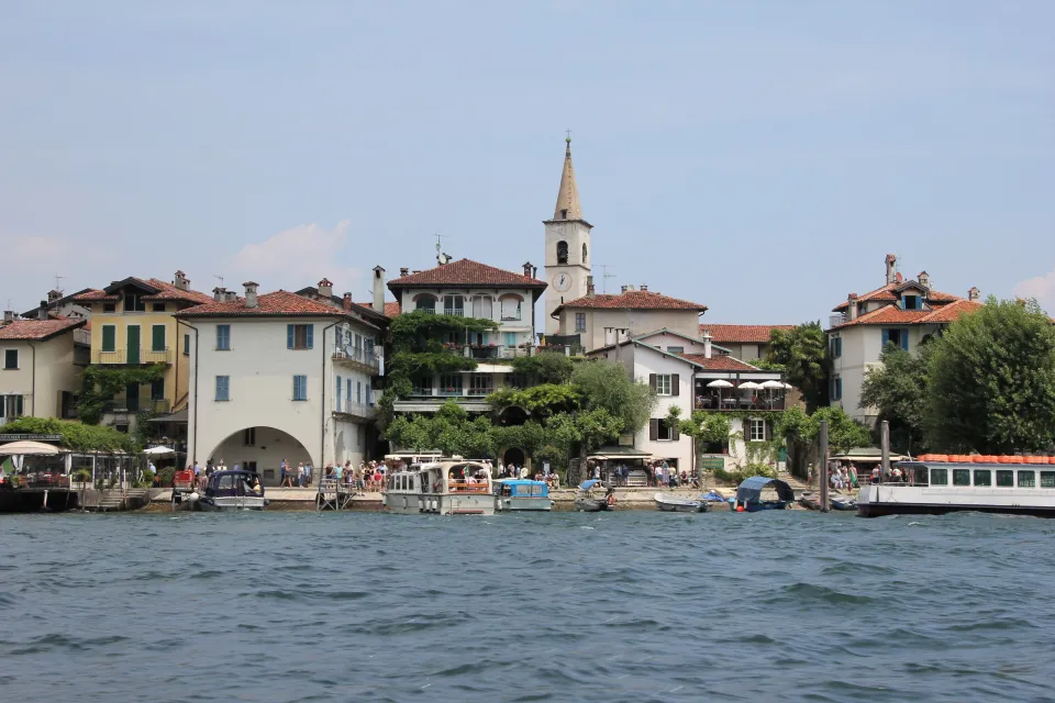 Boats and colourful waterfront buildings below the bell tower on Isola dei Pescatori