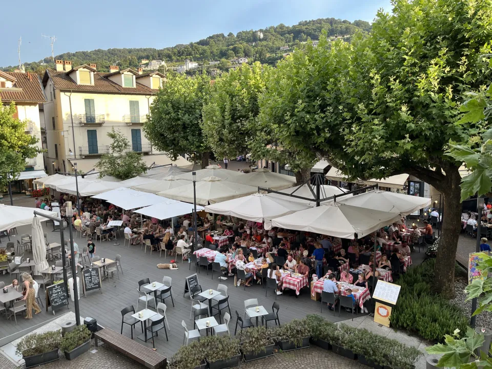 White parasols and outdoor restaurant tables in Piazza Luigi Cadorna in Stresa