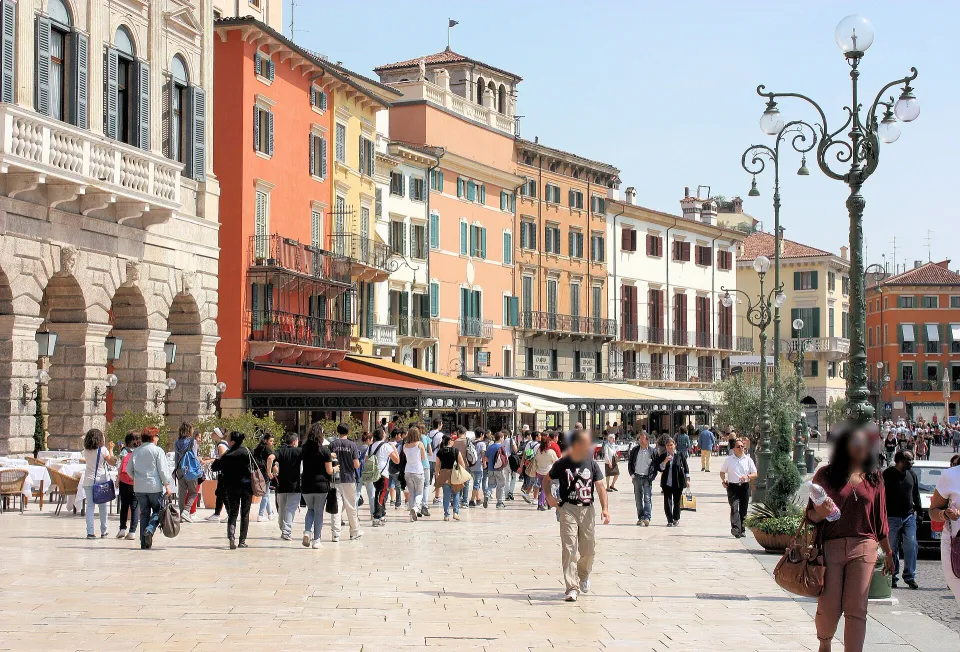 Colourful façades, ornate street lamps and pedestrians along the Liston side of Piazza Bra in Verona