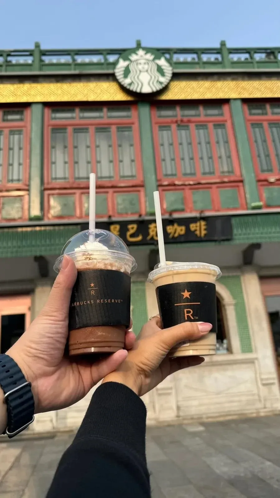 スターバックスの建物を背景に並べた2杯のドリンク