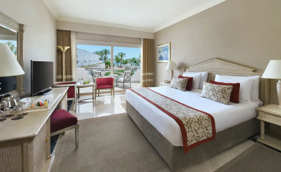 JAZ Elite PalaceのSuperior Room Queen Bed Sea Viewの例。赤いアクセントの寝室と海を望むバルコニー