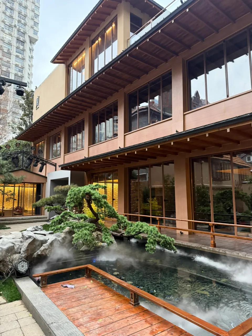 宮宴訪問時の木の建物と水辺に配された松と岩と白い霧