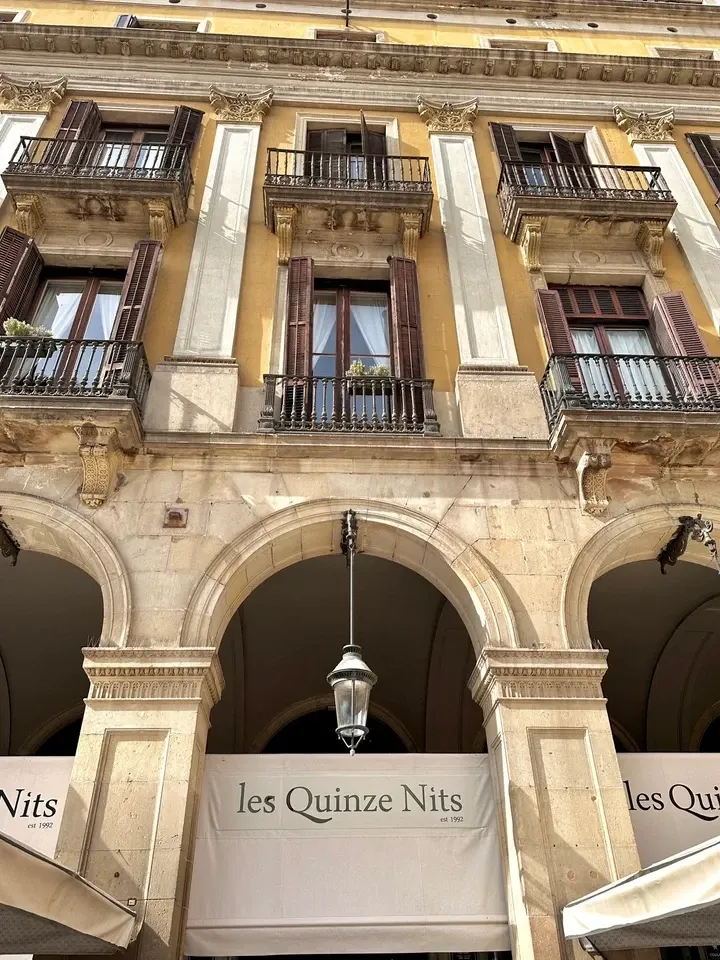 Les Quinze Nitsの外観。広場のアーチの下に、店名入りの白い日よけ。