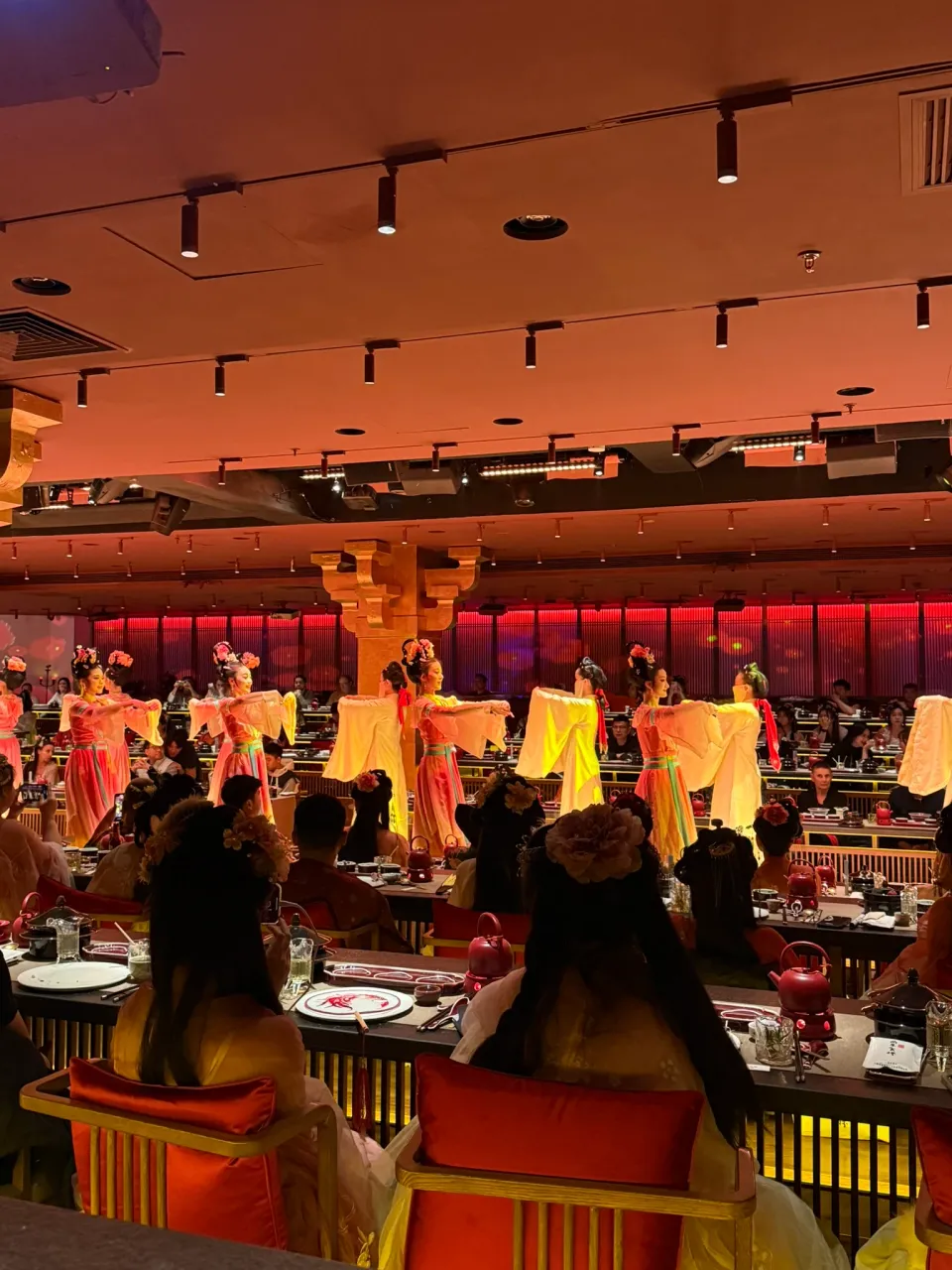 観客席の近くで淡黄色の長い袖を横に広げる宮宴の演者たち