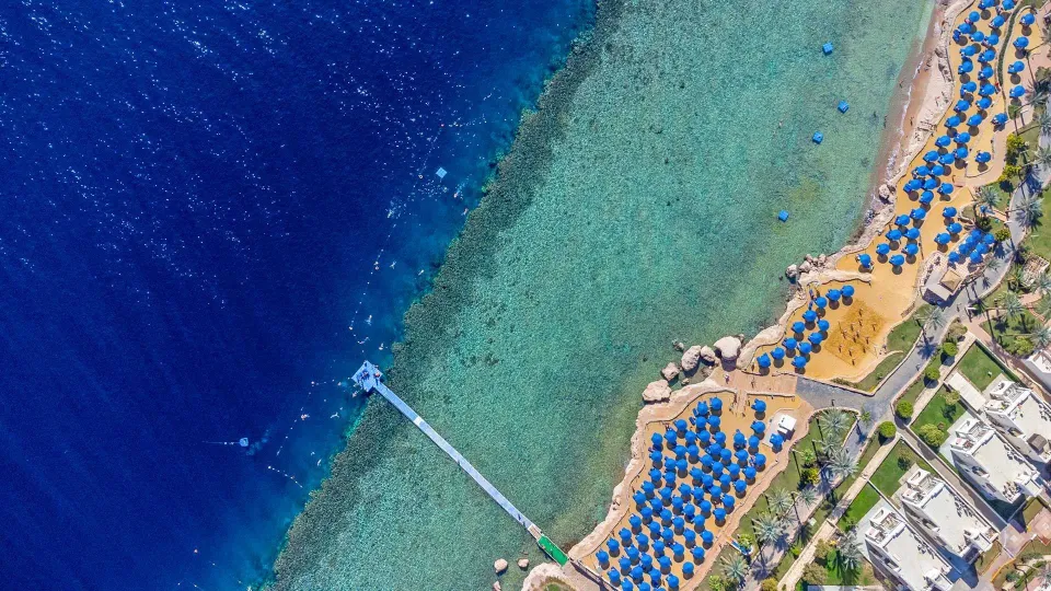 Royal Grandの海岸を見下ろす公式写真。浅いリーフと深い青の海、海へ延びる桟橋