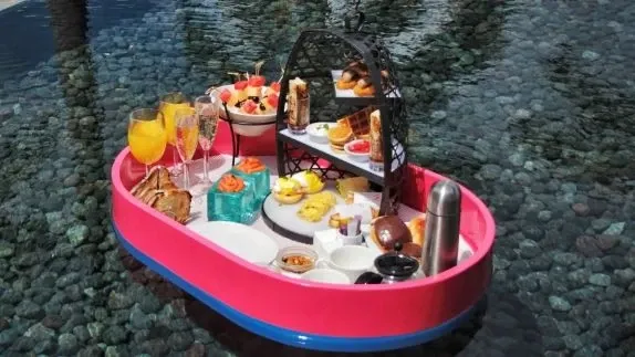 Wバリの水上朝食の紹介例。ピンクのトレーに料理と飲み物が並ぶ。