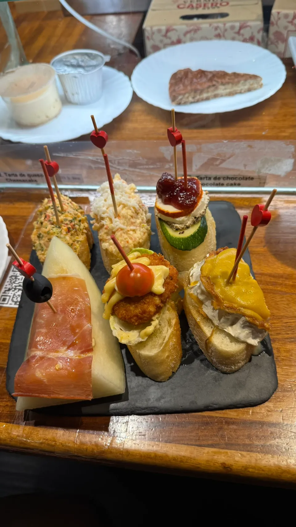 Pincho Jの黒いプレートに盛られた6本のピンチョス