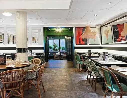 Taller de Tapas Rambla Catalunyaの店内。壁沿いのベンチ席と、緑の枠の向こうの客席。