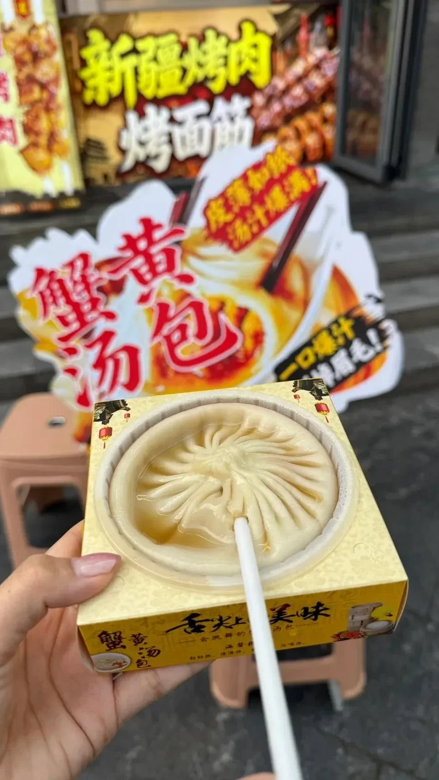 ストローを刺して中のスープを飲む大きな蟹黄湯包
