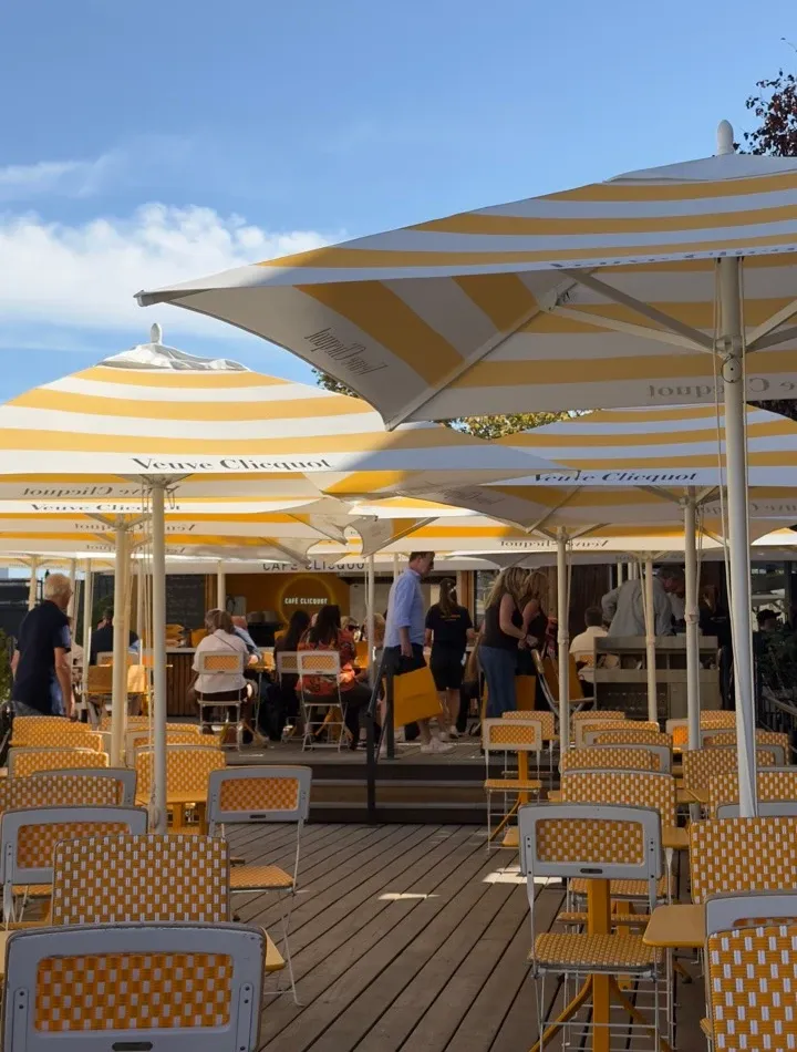 黄色と白のパラソルと椅子が並ぶランスのCafé Clicquot