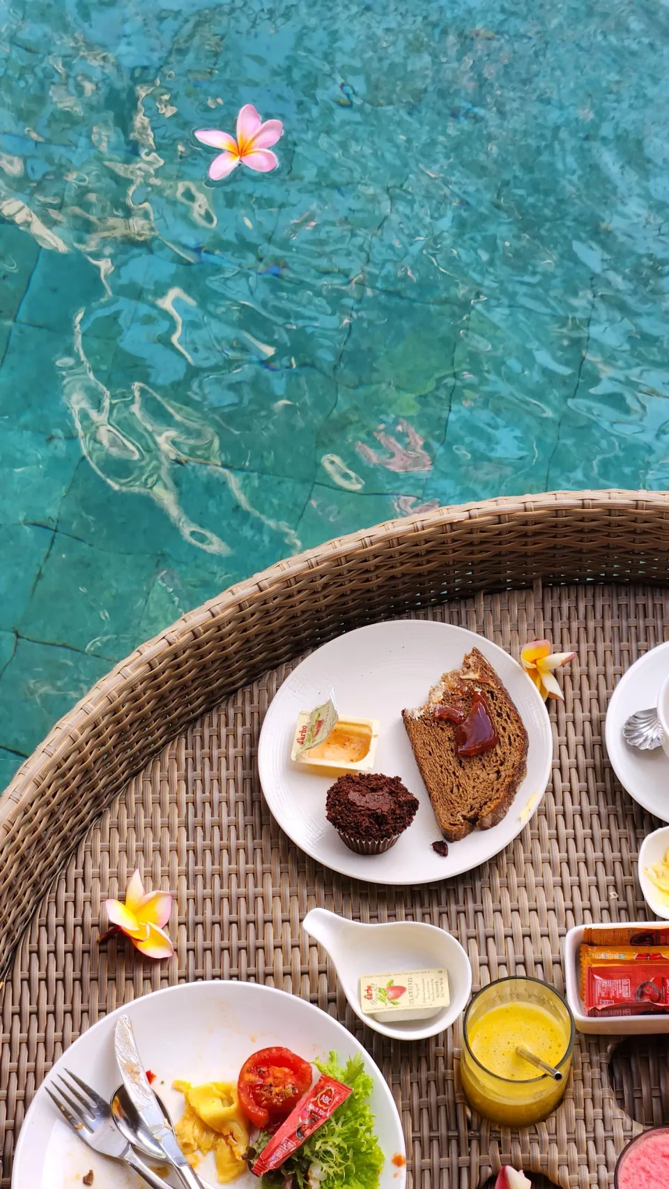 青いプールの水面に浮かぶ朝食のトレー
