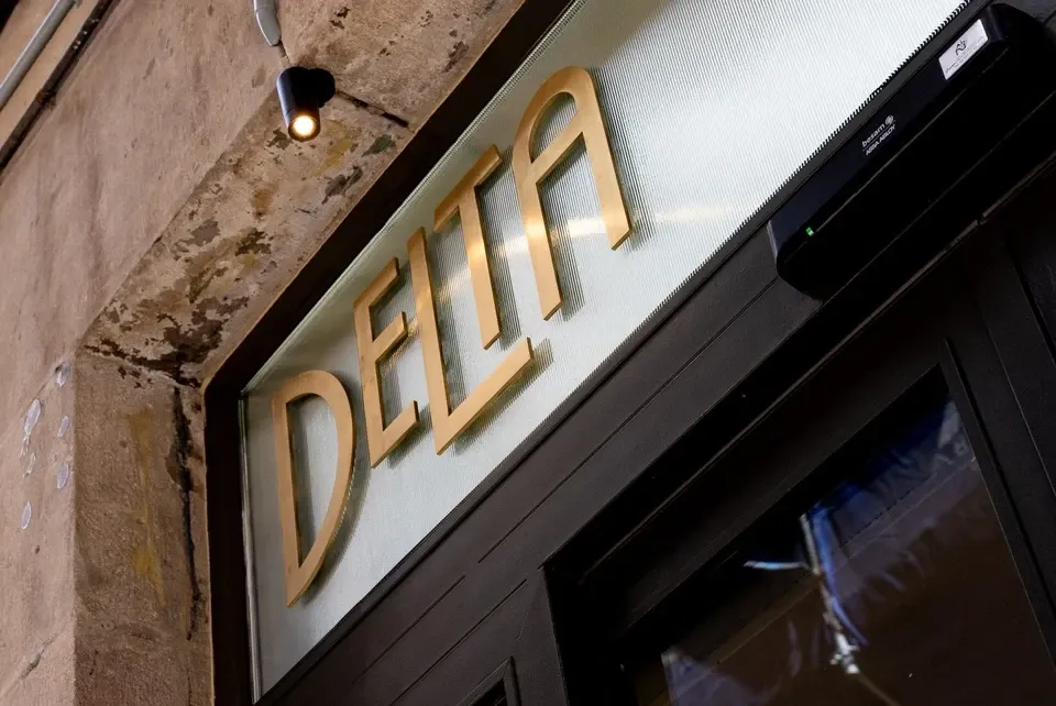 DELTA Arrocería Informalの外観。石の入口に金色の「DELTA」の文字。
