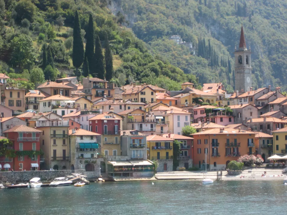 Red, yellow and peach buildings along Varenna’s waterfront below the church bell tower