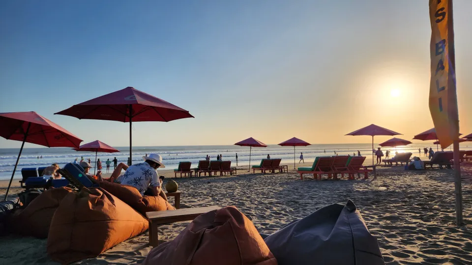 スミニャックのビーチ。ピンクのパラソルと夕日に染まる海